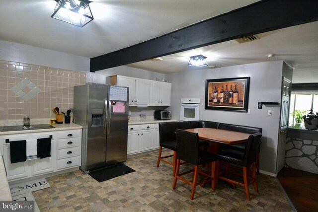 kitchen with baseboard heating and white cabinets