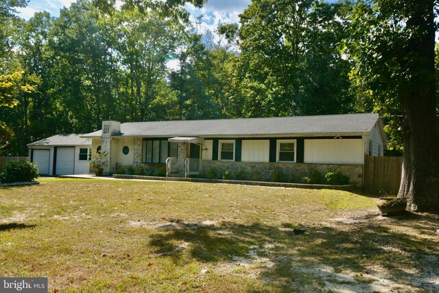 ranch-style house featuring a garage and a front lawn