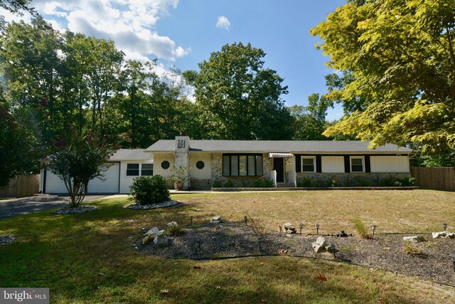 ranch-style home with a garage and a front lawn