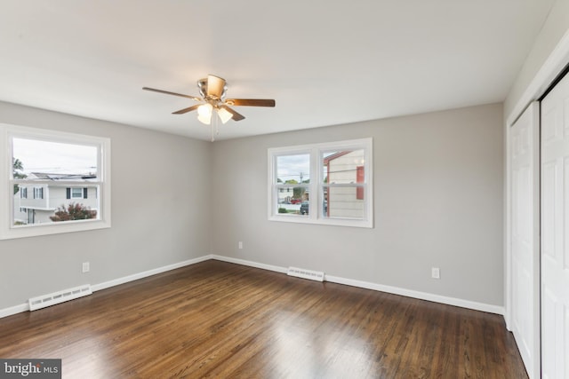 unfurnished bedroom featuring dark wood-type flooring, ceiling fan, and a closet