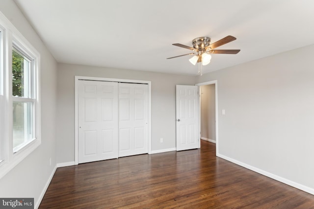 unfurnished bedroom featuring a closet, ceiling fan, and dark hardwood / wood-style flooring