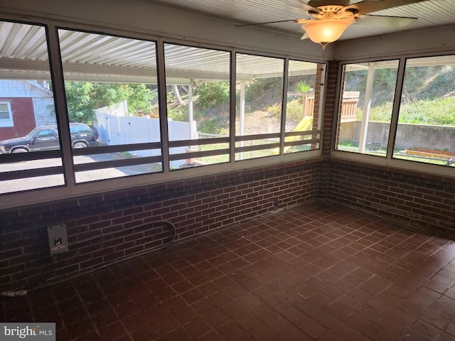 unfurnished sunroom featuring ceiling fan