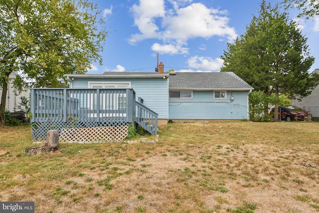 rear view of house featuring a lawn and a wooden deck