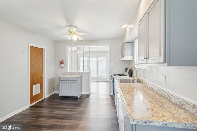 kitchen featuring gray cabinets, ceiling fan, stainless steel range oven, and dark hardwood / wood-style flooring