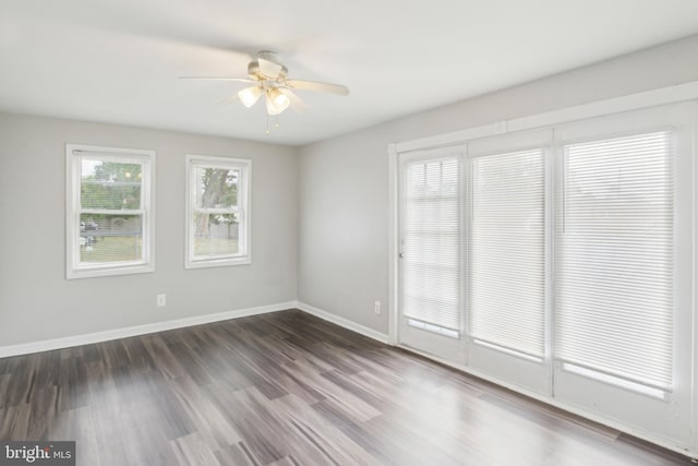 empty room with dark hardwood / wood-style flooring and ceiling fan