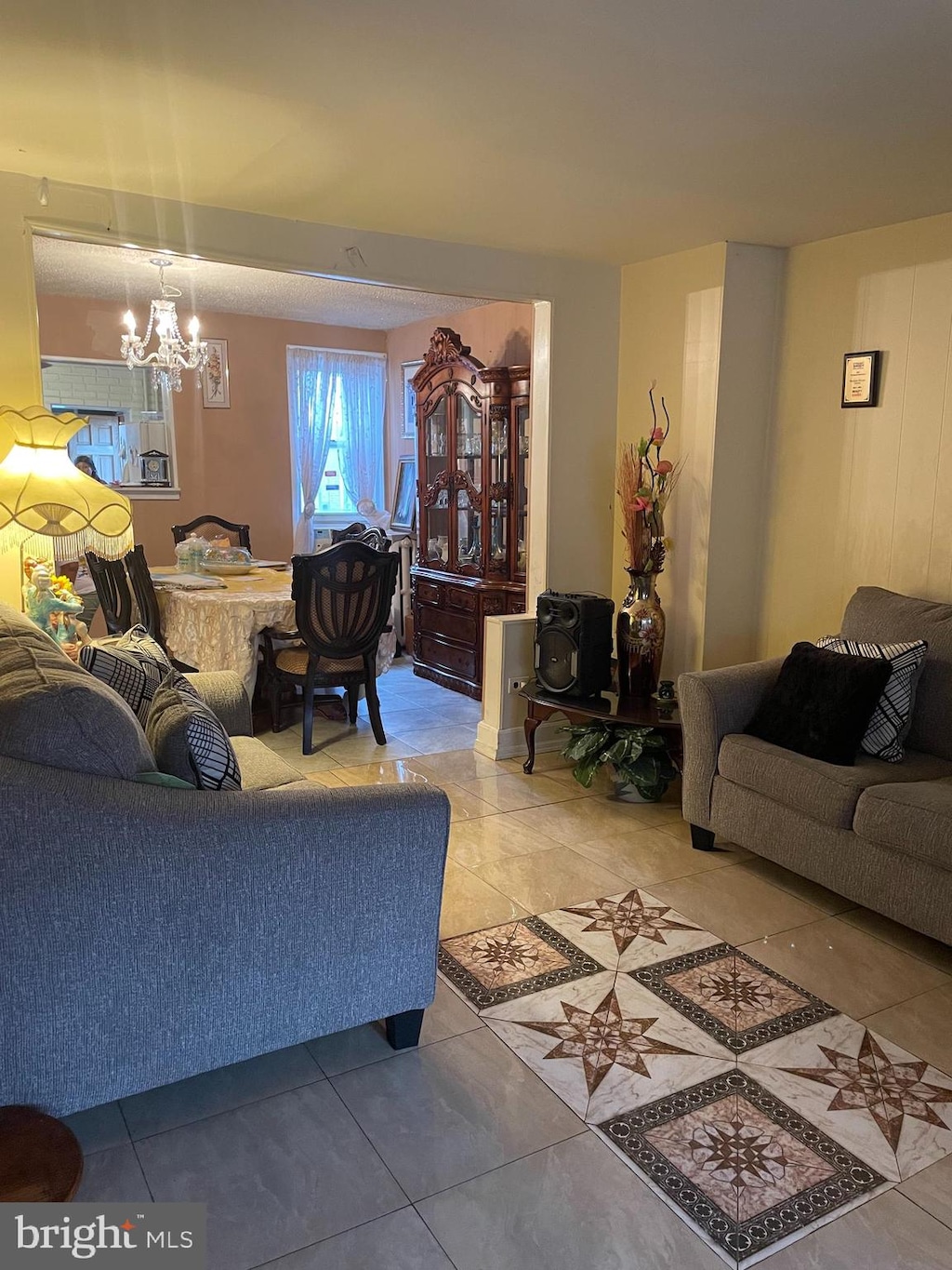 tiled living room featuring a chandelier