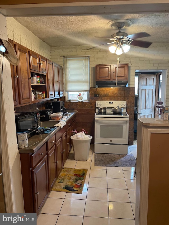 kitchen featuring light tile patterned flooring, ceiling fan, a textured ceiling, and white electric range oven