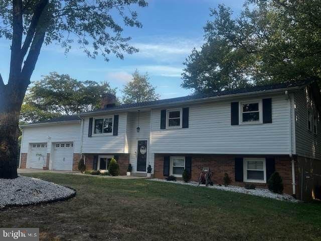 raised ranch with a garage and a front lawn