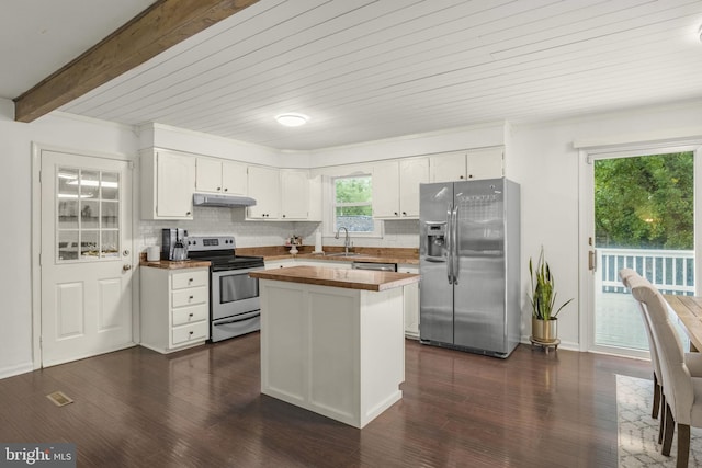 kitchen with white cabinets, appliances with stainless steel finishes, a kitchen island, and beamed ceiling