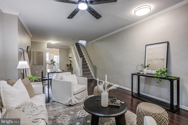 living room with crown molding, ceiling fan, and dark wood-type flooring