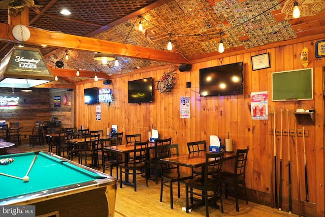 game room with billiards, beamed ceiling, wooden walls, and light hardwood / wood-style floors