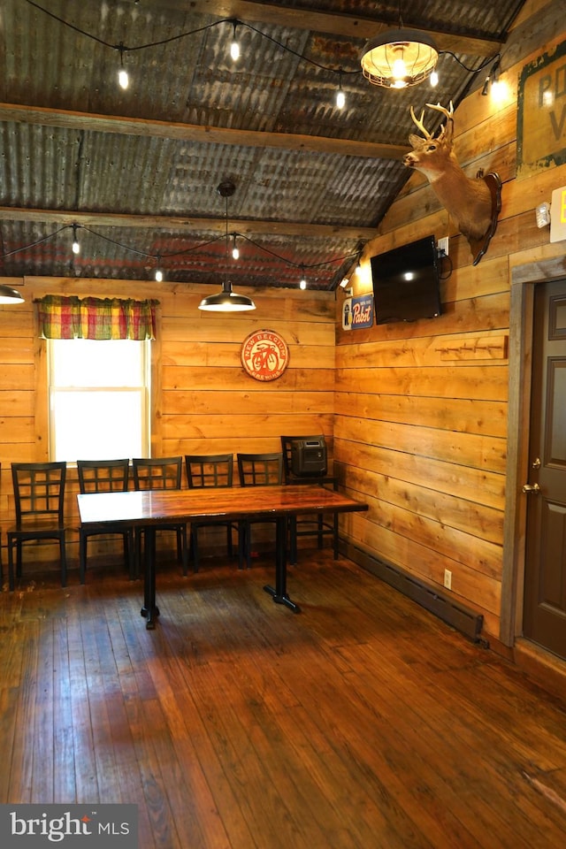 recreation room with hardwood / wood-style flooring, wooden walls, and vaulted ceiling with beams