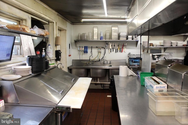 kitchen featuring open shelves, stainless steel counters, and dark tile patterned flooring