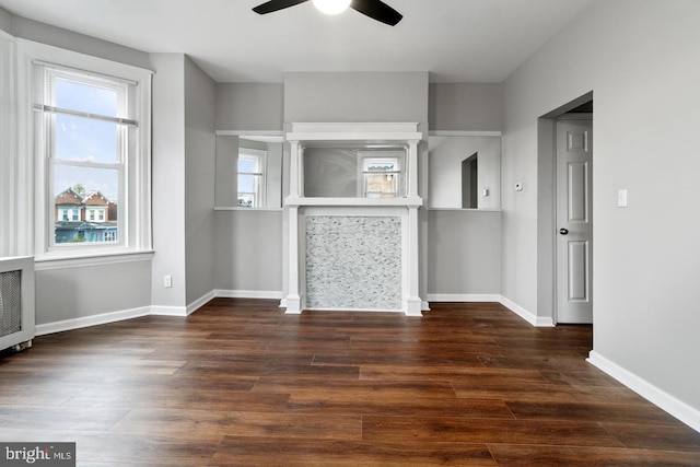 unfurnished living room with ceiling fan and dark hardwood / wood-style flooring