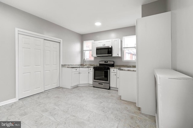 kitchen featuring appliances with stainless steel finishes, white cabinetry, and sink