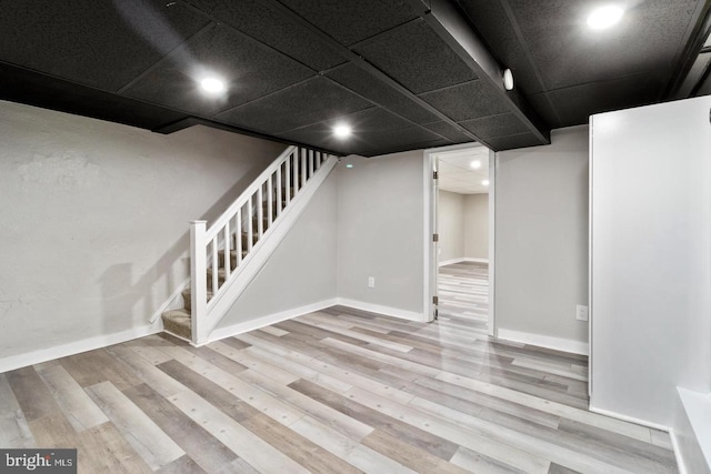 basement with light hardwood / wood-style flooring