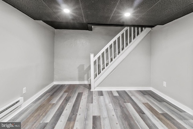 basement with hardwood / wood-style floors and baseboard heating