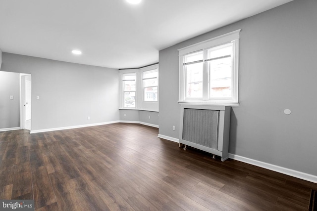 interior space with radiator heating unit and dark hardwood / wood-style floors