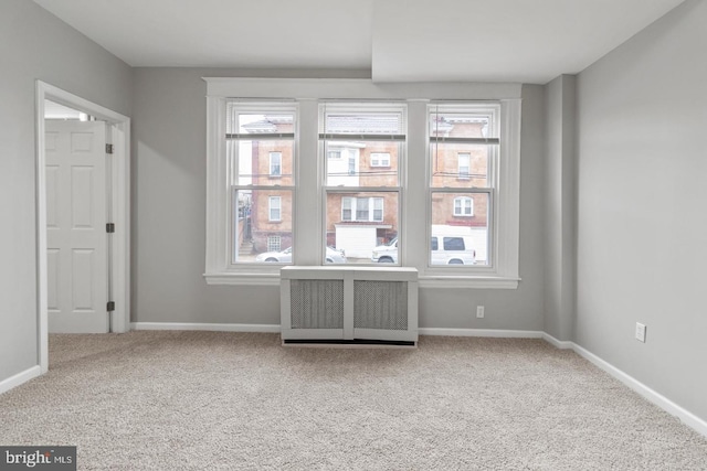 carpeted empty room with radiator heating unit