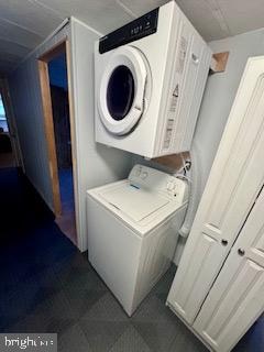 laundry room featuring stacked washer / drying machine