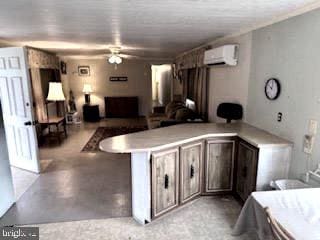 kitchen featuring ceiling fan, dark brown cabinetry, an AC wall unit, and kitchen peninsula