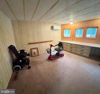 workout area with carpet, built in desk, a wall mounted AC, and wood walls