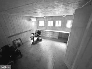 basement with wood walls and an AC wall unit