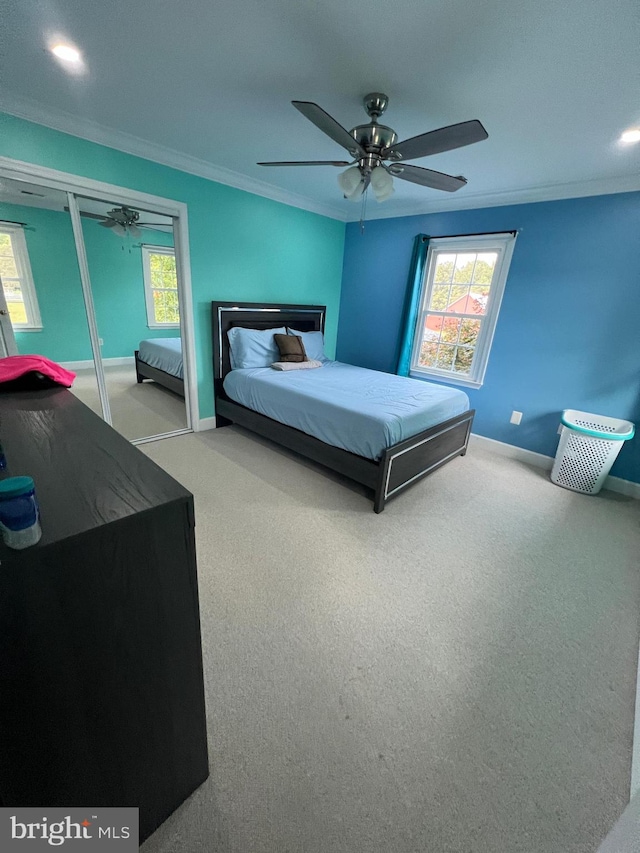 carpeted bedroom with crown molding and ceiling fan