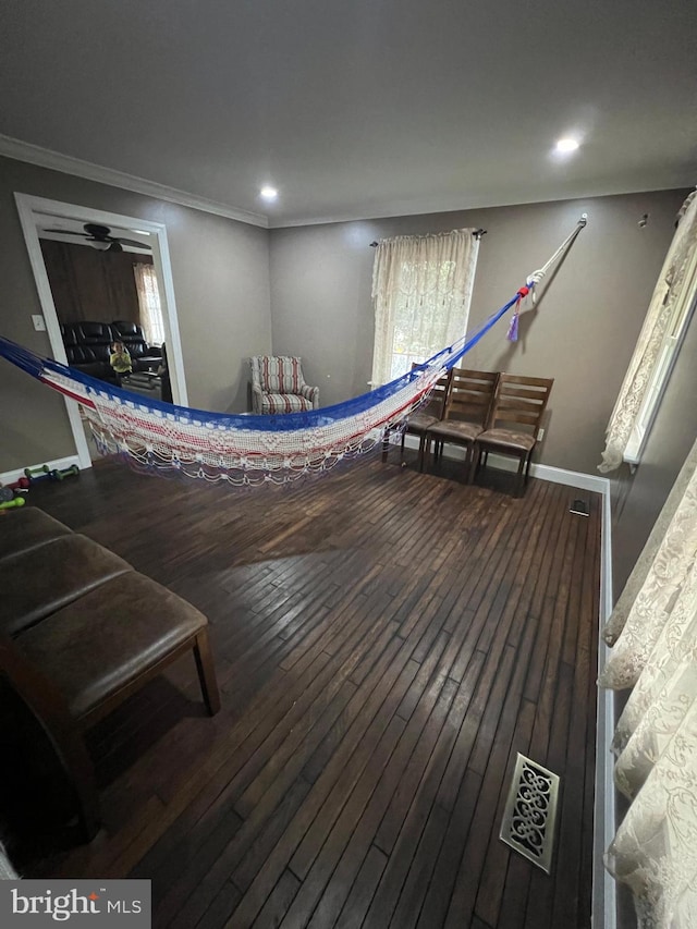 interior space featuring ornamental molding, wood-type flooring, and ceiling fan