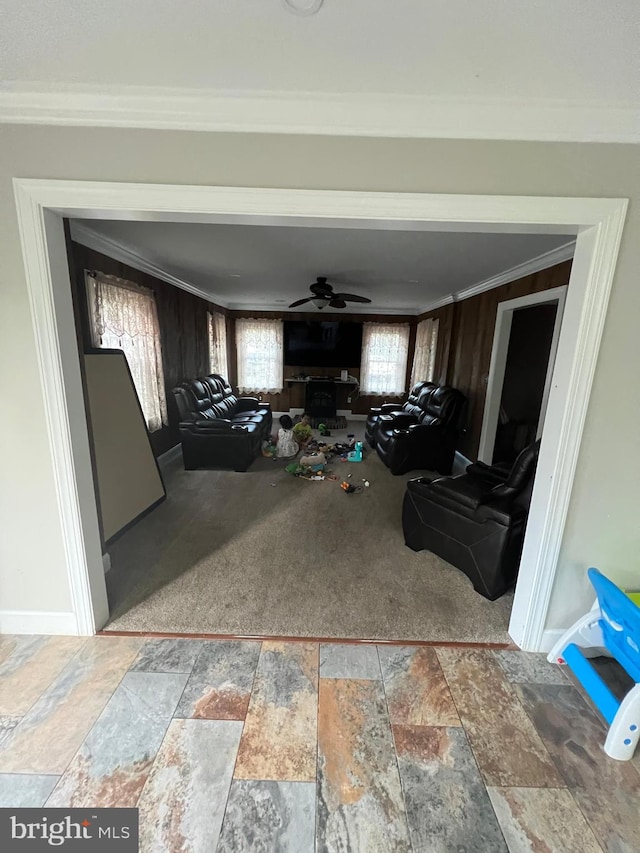 living room with carpet, ceiling fan, and ornamental molding