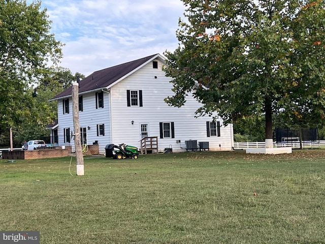 back of house with cooling unit and a yard