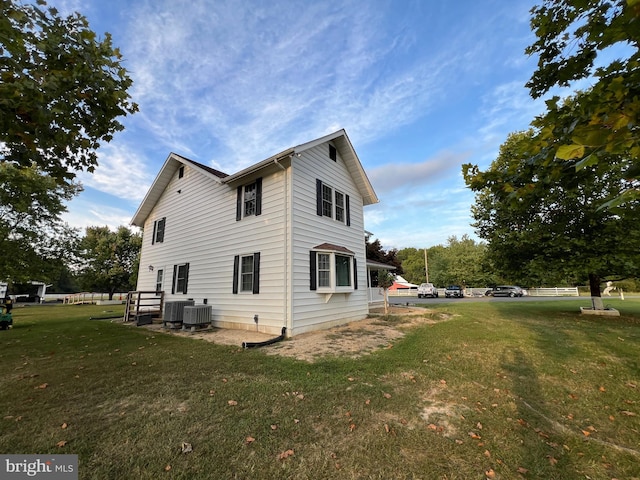 view of side of property with a yard and central air condition unit