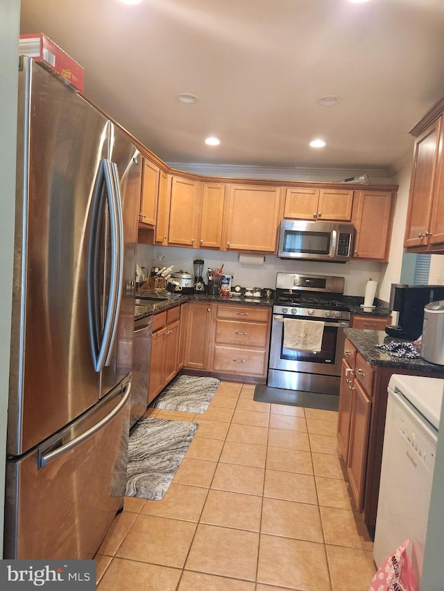 kitchen featuring dark stone countertops, stainless steel appliances, and light tile patterned floors