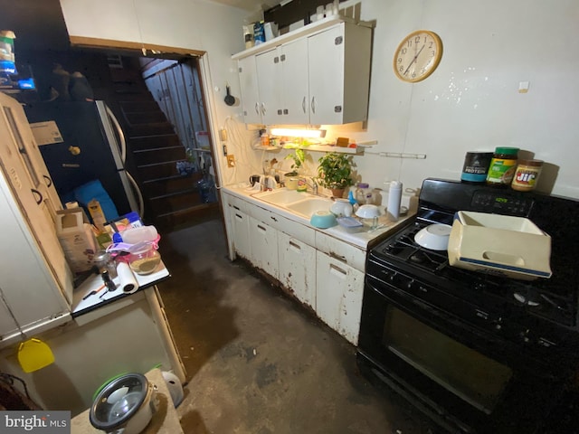 kitchen featuring sink, gas range gas stove, and white cabinetry