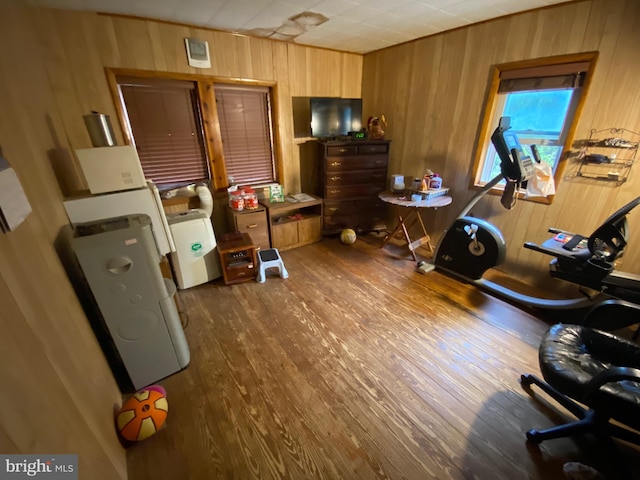 interior space with hardwood / wood-style floors, wooden walls, and washer / dryer