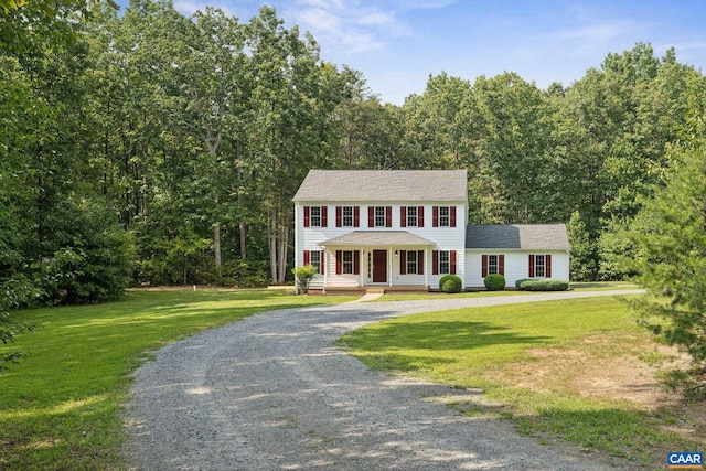 colonial-style house featuring a porch and a front lawn