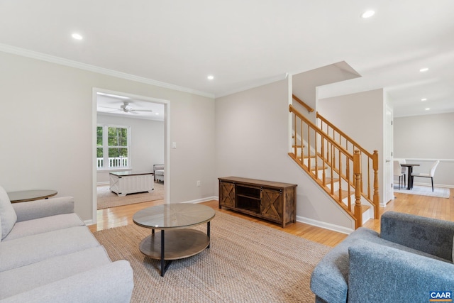 living room featuring light wood-type flooring, ornamental molding, and ceiling fan