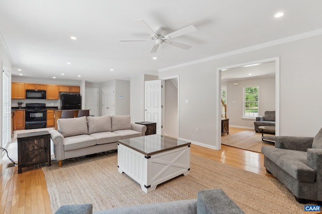 living room featuring crown molding, ceiling fan, and light hardwood / wood-style floors