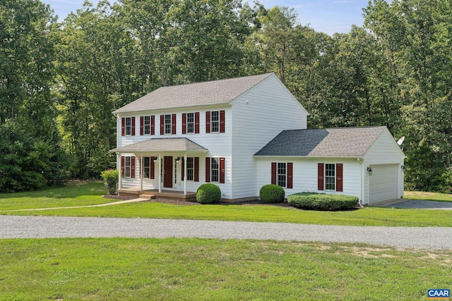 colonial house with a front lawn, a garage, and a porch