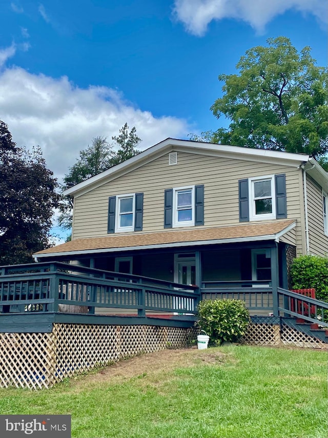 view of front of home featuring a front yard and a deck