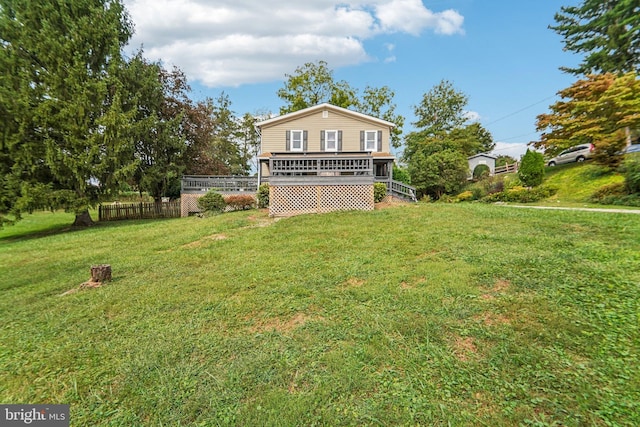 exterior space featuring a wooden deck and a lawn