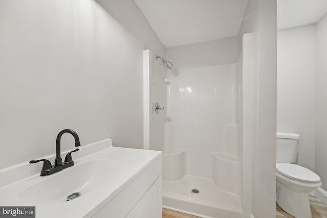 bathroom featuring vanity, a shower, toilet, and hardwood / wood-style flooring