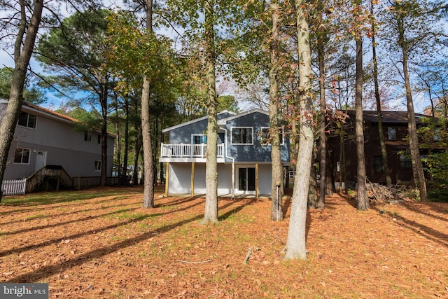 rear view of property with a deck and a lawn