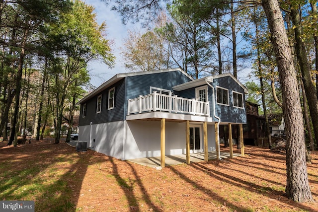 view of property exterior featuring central air condition unit, a wooden deck, and a patio area