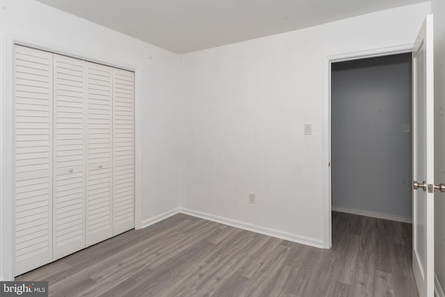 unfurnished bedroom with light hardwood / wood-style flooring and a closet