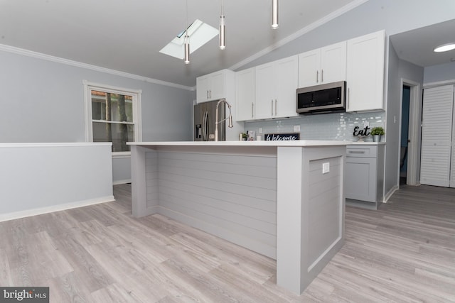 kitchen featuring light wood-type flooring, appliances with stainless steel finishes, an island with sink, and lofted ceiling with skylight