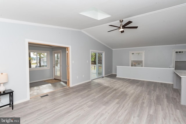 unfurnished living room with a healthy amount of sunlight, ceiling fan, lofted ceiling with skylight, and light hardwood / wood-style floors