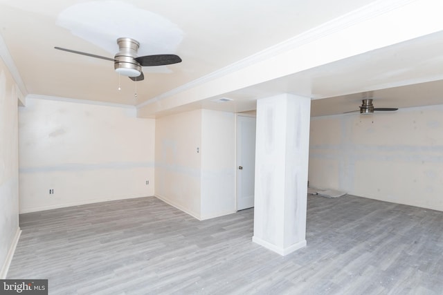 basement with crown molding, light hardwood / wood-style flooring, and ceiling fan