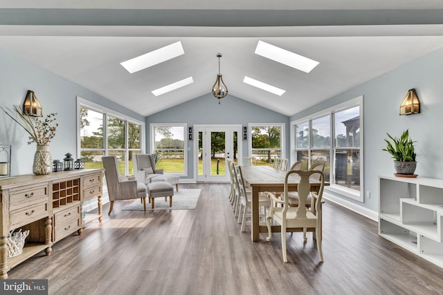 dining space featuring lofted ceiling with skylight and dark hardwood / wood-style floors