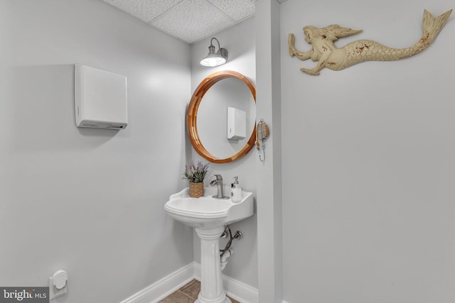 bathroom featuring a paneled ceiling and tile patterned flooring